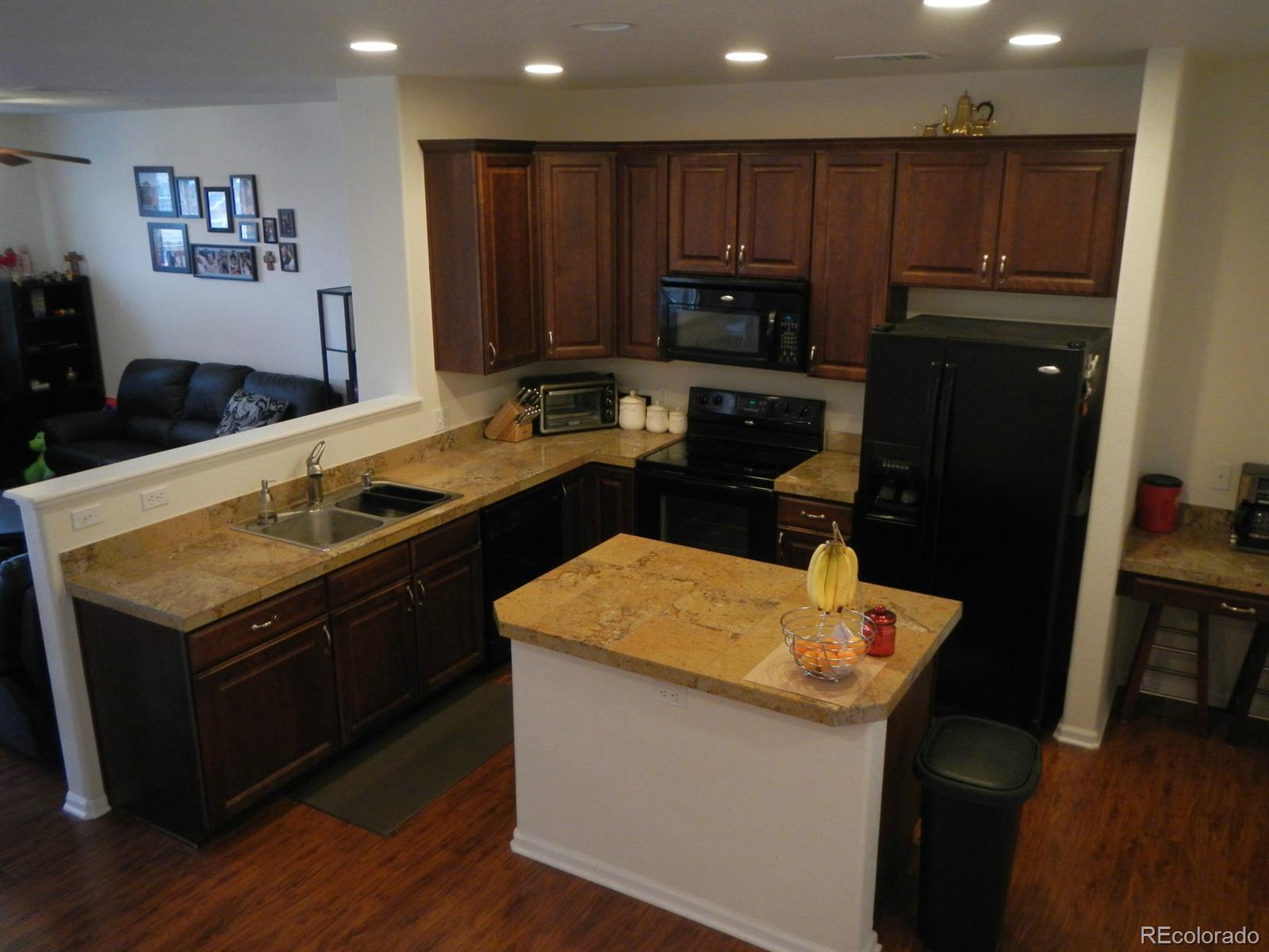 3652 South Perth Circle, Unit 102 Aurora, CO 80013 - Photo 6 of 17 a kitchen with wooden cabinets sink and stove