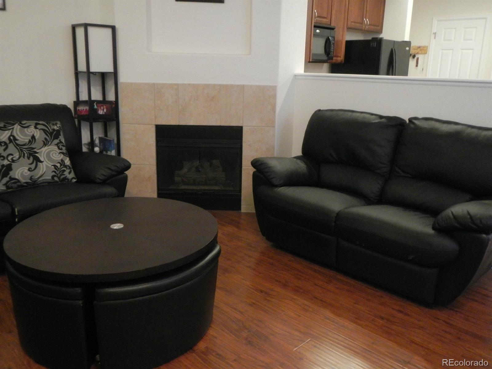 3652 South Perth Circle, Unit 102 Aurora, CO 80013 - Photo 7 of 17 a living room with furniture and a fireplace