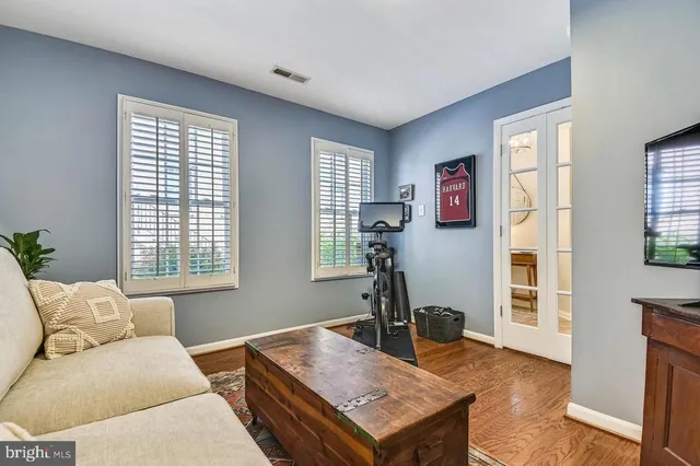 a kitchen with stainless steel appliances granite countertop a stove top oven a sink dishwasher a refrigerator and white cabinets with wooden floor