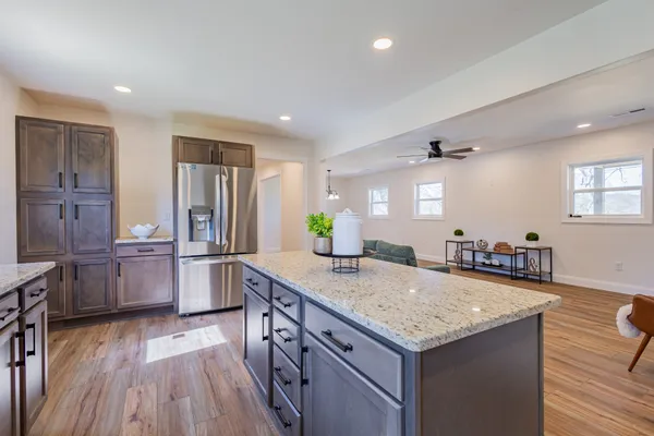 a kitchen with granite countertop a sink a counter space and stainless steel appliances