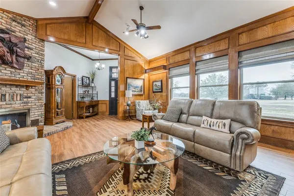 a living room with furniture a fireplace and a large window