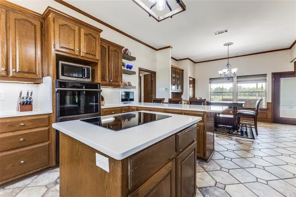 a kitchen that has a sink a stove and chairs in it