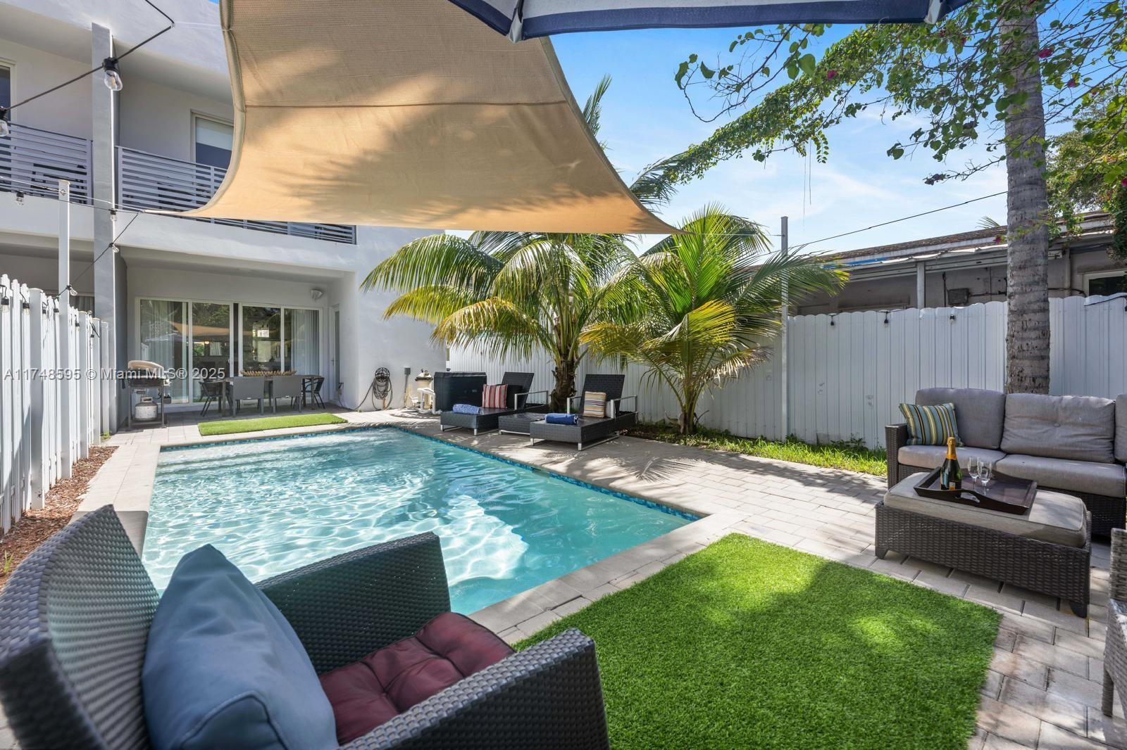 3570 Southwest 23rd Street, Unit 3570 Miami, FL 33145 - Photo 11 of 40 a view of a backyard with couches table and chairs under an umbrella