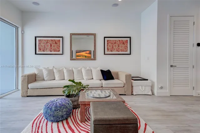 a living room with furniture kitchen view and a chandelier