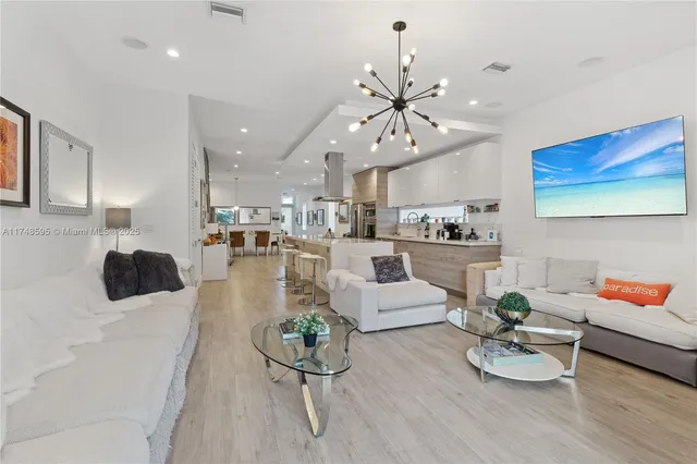 a large kitchen with stainless steel appliances a lot of counter space and a dining table