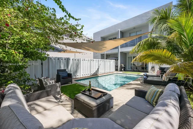 a living room with stainless steel appliances furniture wooden floor and a view of kitchen