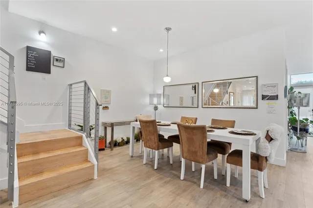 a living room with stainless steel appliances furniture a flat screen tv and kitchen view