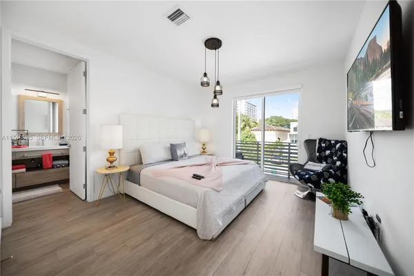 a living room with furniture a flat screen tv and a large window