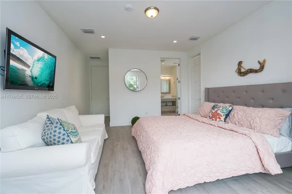 a bedroom with bed and a flat screen tv