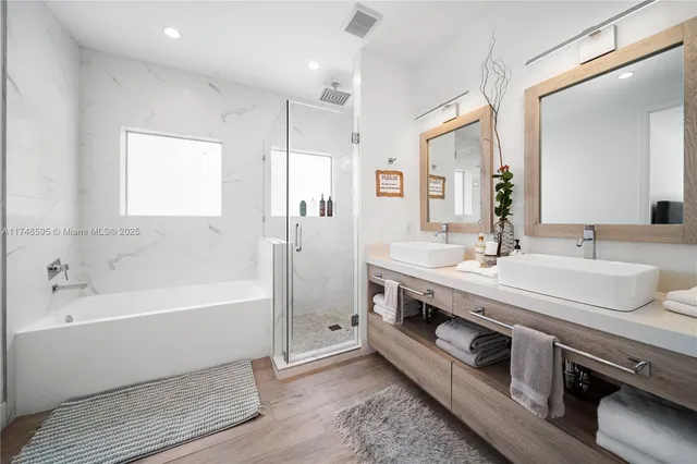 a bathroom with a double vanity sink a mirror and a bathtub
