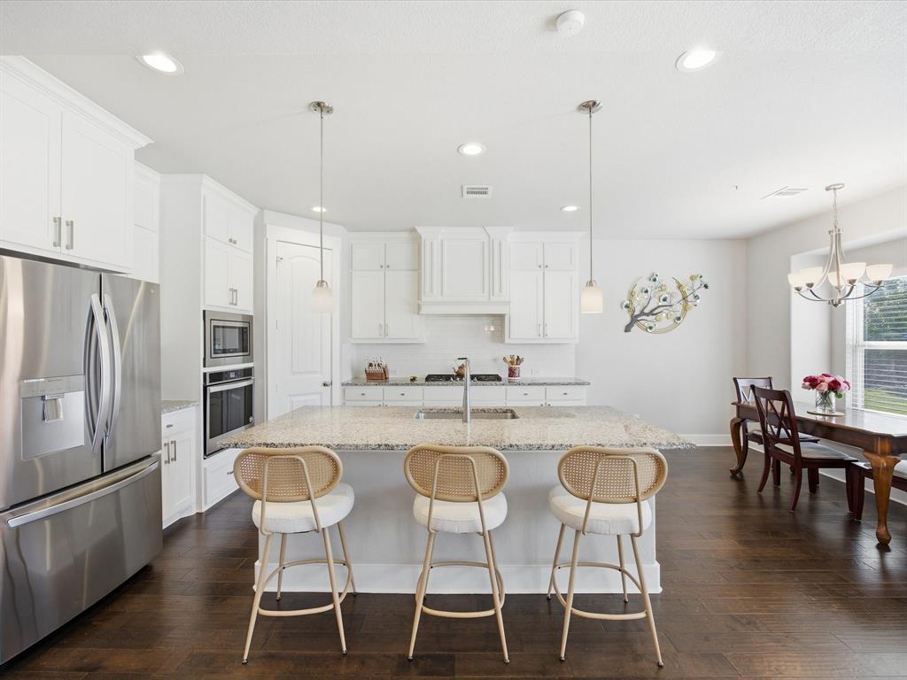 146 Old Bridge Road Waxahachie, TX 75165 - Photo 16 of 40 a kitchen with stainless steel appliances granite countertop a dining table chairs stove refrigerator and cabinets