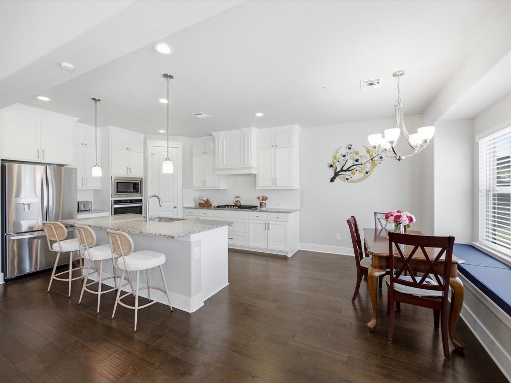 146 Old Bridge Road Waxahachie, TX 75165 - Photo 17 of 40 a kitchen with stainless steel appliances granite countertop a dining table chairs and a refrigerator