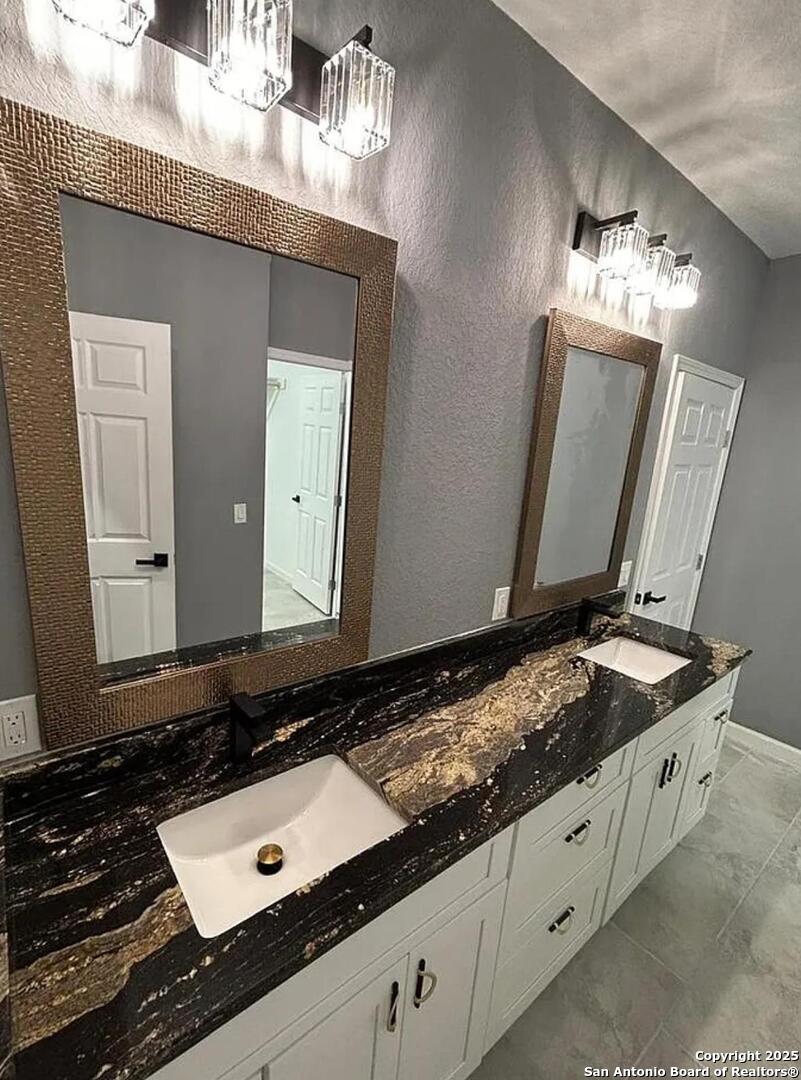 48 Grey Fox Poteet, TX 78065 - Photo 9 of 16 a bathroom with a granite countertop double vanity sink and a mirror