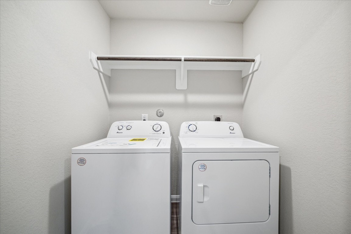 715 Gavin Walker Drive Rosharon, TX 77583 - Photo 15 of 15 This photo shows a compact laundry room with a washer and dryer set, featuring a simple shelf above for storage.