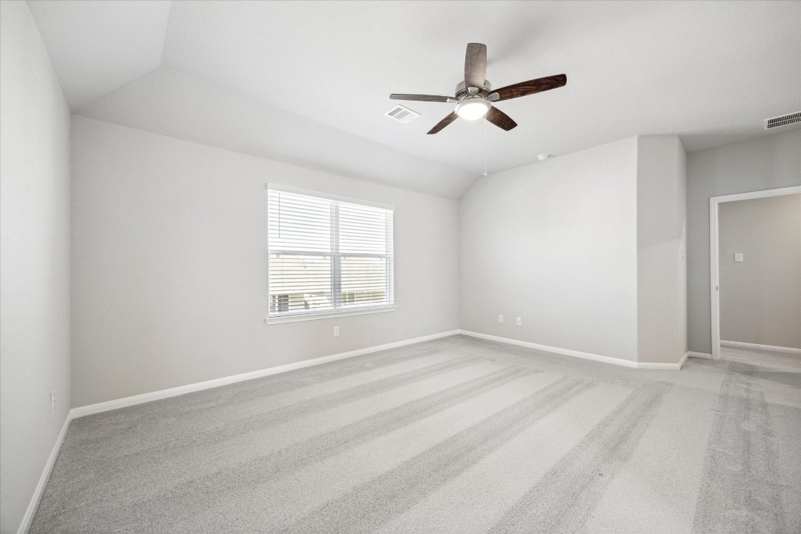 715 Gavin Walker Drive Rosharon, TX 77583 - Photo 6 of 15 This is a bright, spacious bedroom with a neutral color palette, featuring a ceiling fan, large window for natural light, and plush carpeting.