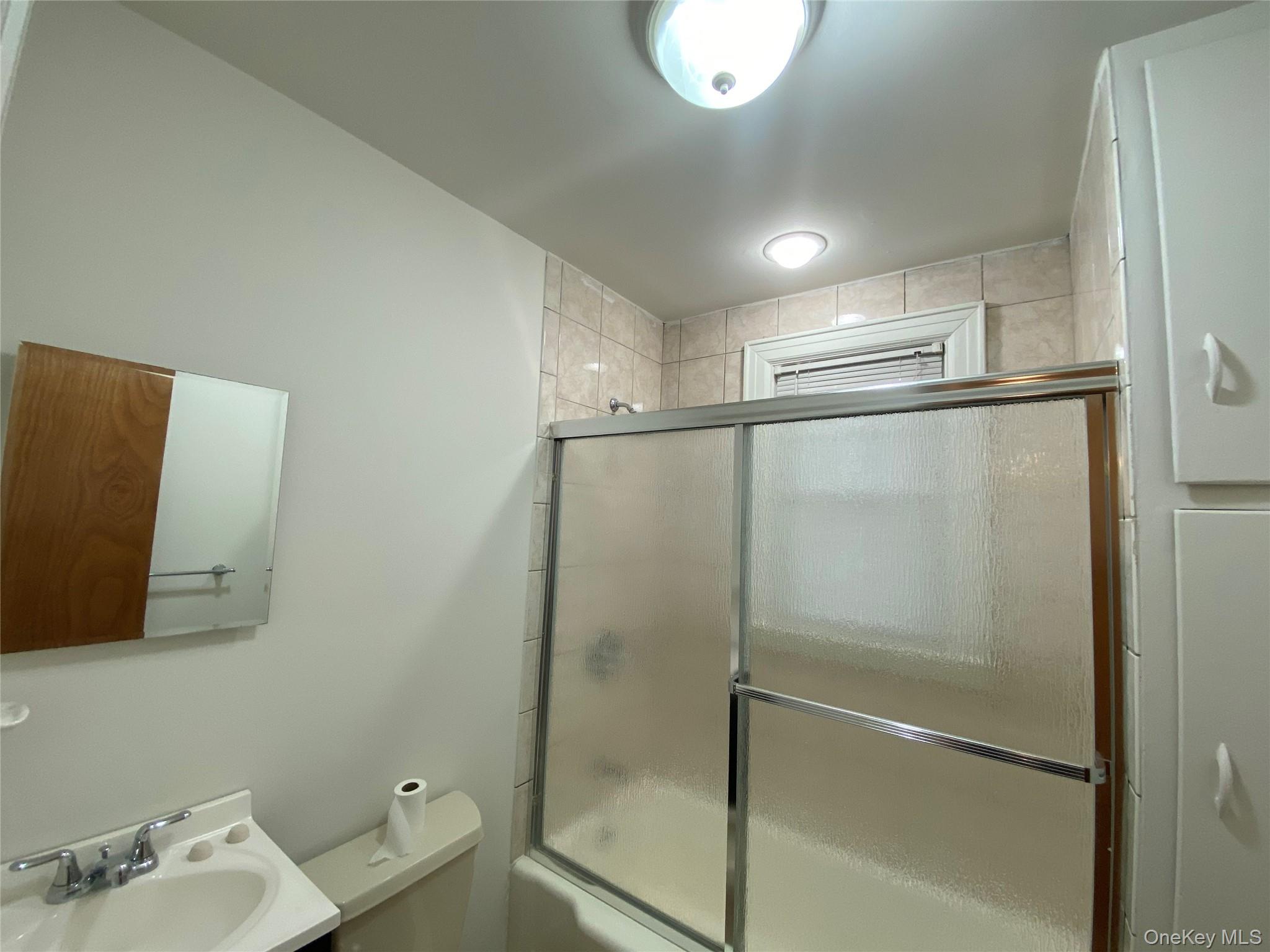 90 Orchard Road, Unit 2 Mahopac, NY 10541 - Photo 6 of 7 a bathroom with a granite countertop sink mirror and toilet