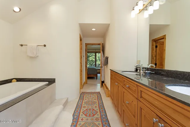 a large bathroom with a double vanity sink and a bathtub