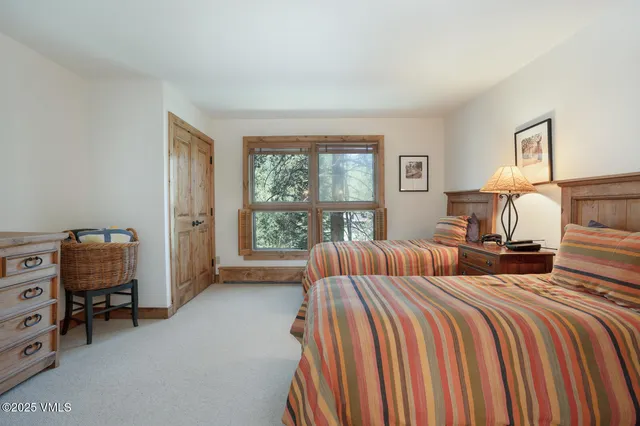 a bedroom with two beds and a window