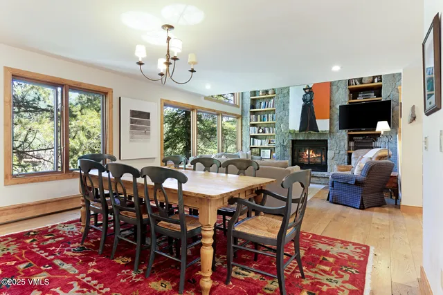 a view of a dining room with furniture a chandelier and wooden floor