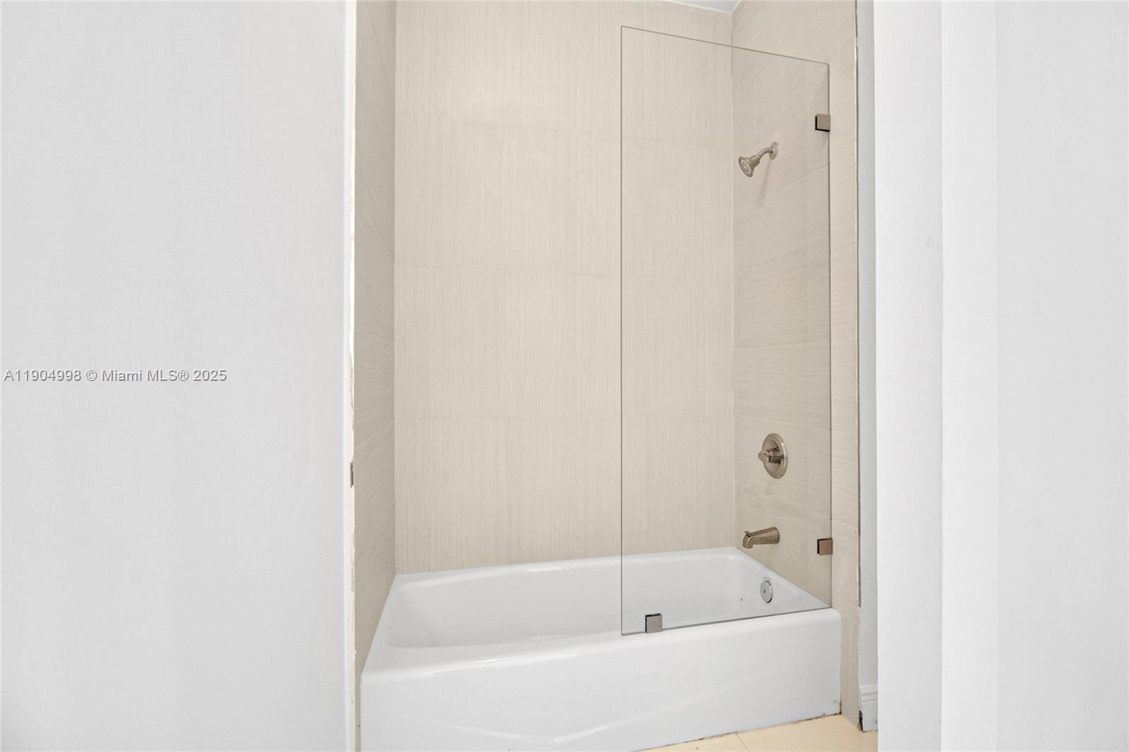 425 Southwest 129th Avenue Miami, FL 33184 - Photo 14 of 24 a white bath tub sitting next to a white wooden wall