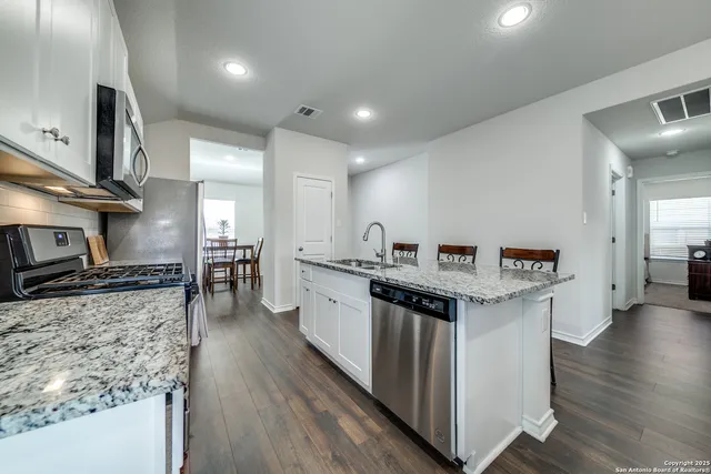 a kitchen with stainless steel appliances granite countertop a sink stove and refrigerator