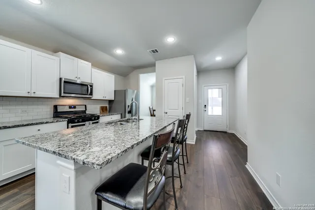 a kitchen with granite countertop kitchen island cabinets and wooden floor