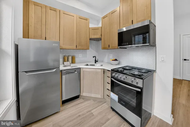 a kitchen with stainless steel appliances a refrigerator stove and microwave