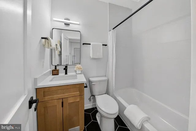 a bathroom with a sink toilet vanity and shower