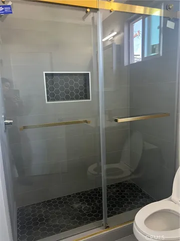 a bathroom with a toilet and a shower