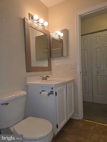 a bathroom with a toilet a sink a vanity and mirror