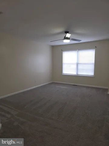 an empty room with a window and a ceiling fan