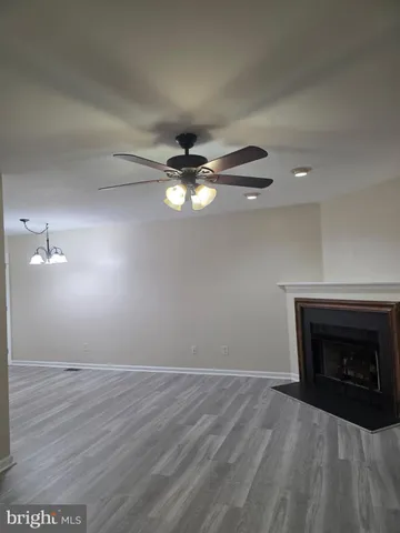 a view of empty room with wooden floor and fireplace