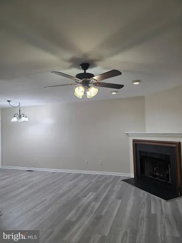 a view of empty room with wooden floor and fireplace