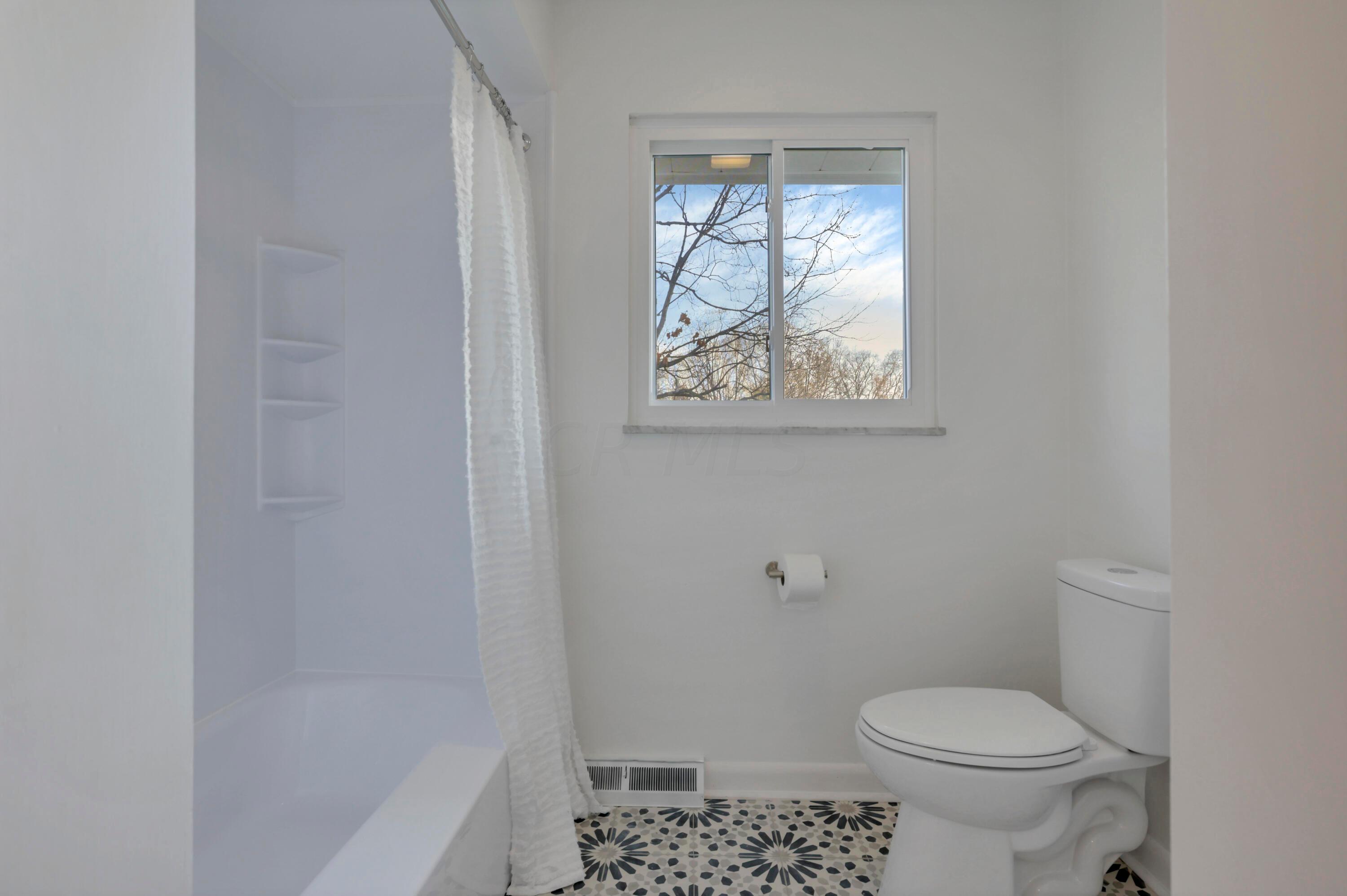 2275 Haverford Road Columbus, OH 43220 - Photo 32 of 57 The hallway full bath features a double vanity, new fixtures, updated lighting, tile floors, bathtub and shower.