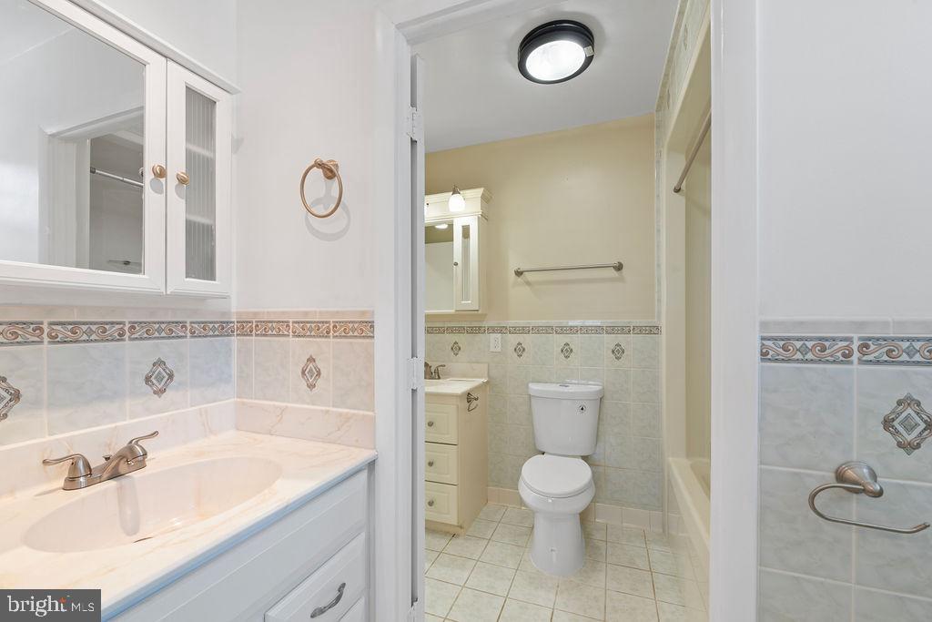 8003 Allentown Road Fort Washington, MD 20744 - Photo 23 of 43 a bathroom with a granite countertop sink mirror vanity and toilet