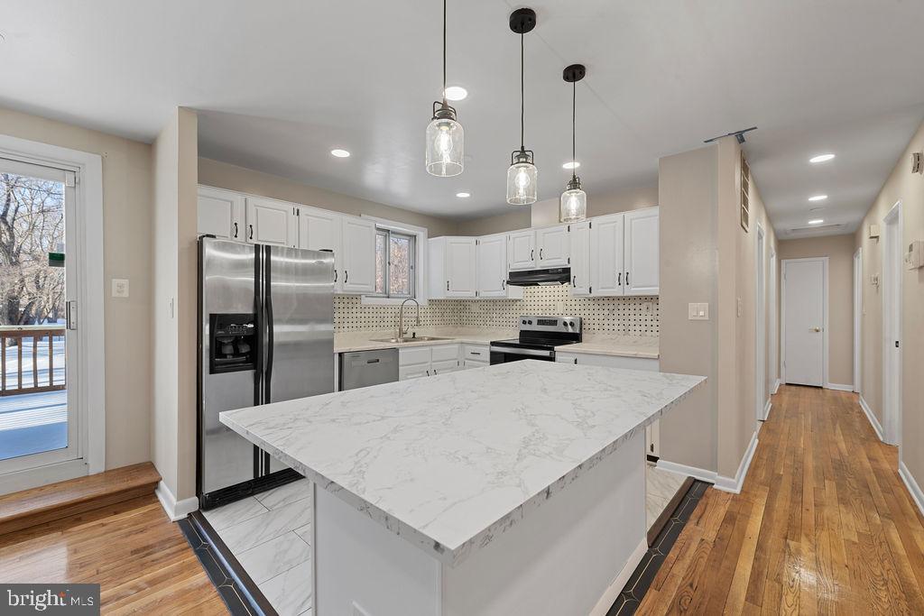8003 Allentown Road Fort Washington, MD 20744 - Photo 7 of 43 a large kitchen with kitchen island a large counter top space a sink stainless steel appliances and cabinets