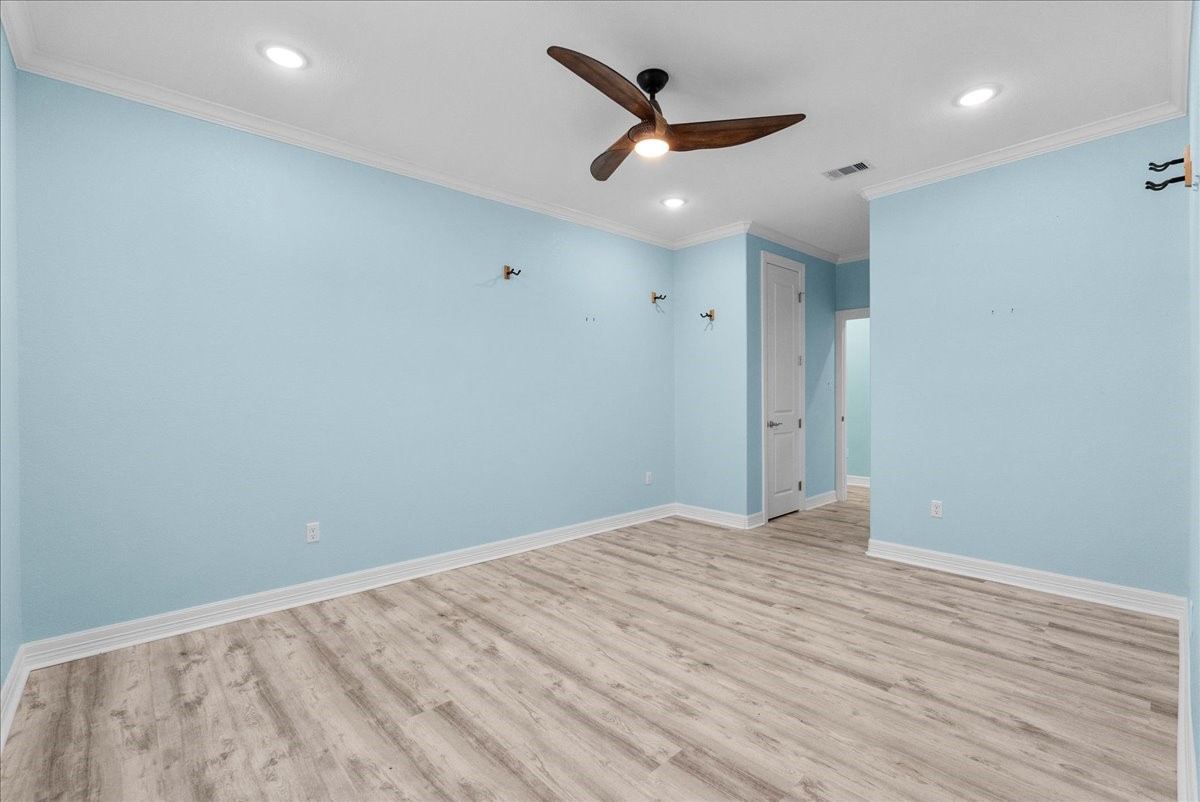 6 Trout Lane Freeport, TX 77541 - Photo 24 of 40 an empty room with wooden floor and a ceiling fan