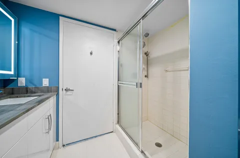 a bathroom with a granite countertop shower mirror and a sink