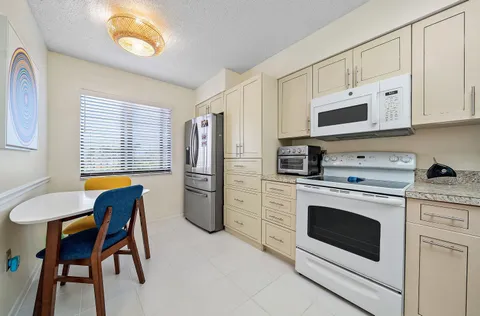 a kitchen with stainless steel appliances white cabinets a stove a sink and a refrigerator