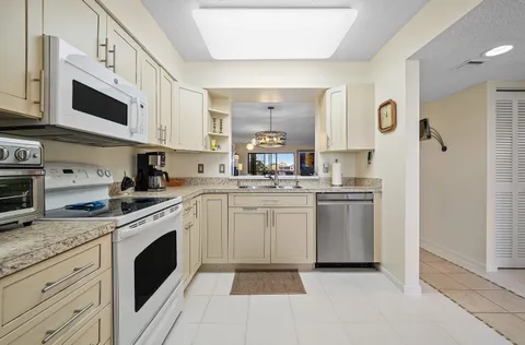 a kitchen with a sink stove and white cabinets