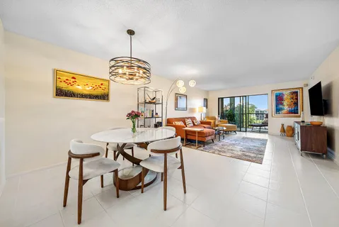 a living room with furniture a chandelier and a flat screen tv