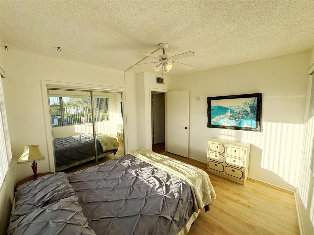 310 South Cypress Road, Unit 729 Pompano Beach, FL 33060 - Photo 18 of 30 a bedroom with a bed and a chandelier
