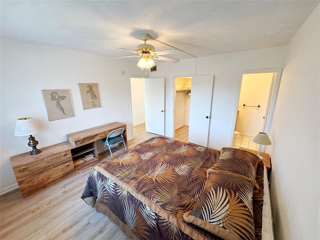 310 South Cypress Road, Unit 729 Pompano Beach, FL 33060 - Photo 23 of 30 a spacious bedroom with a bed and a chandelier