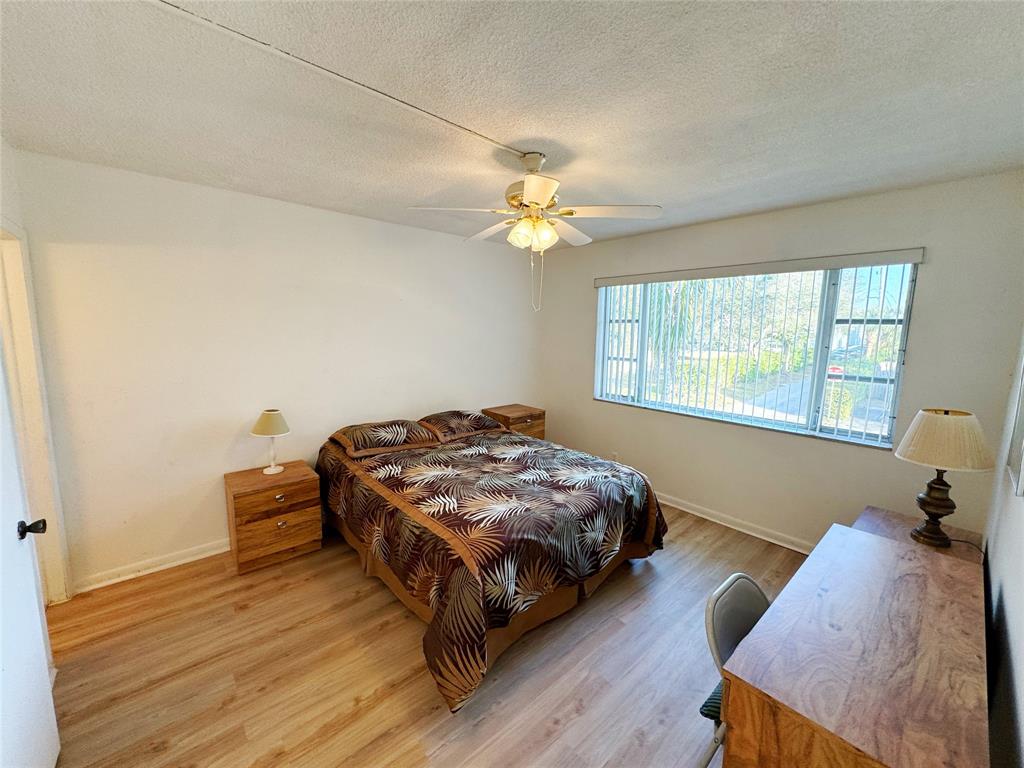 310 South Cypress Road, Unit 729 Pompano Beach, FL 33060 - Photo 25 of 30 a bedroom with a bed and a chandelier