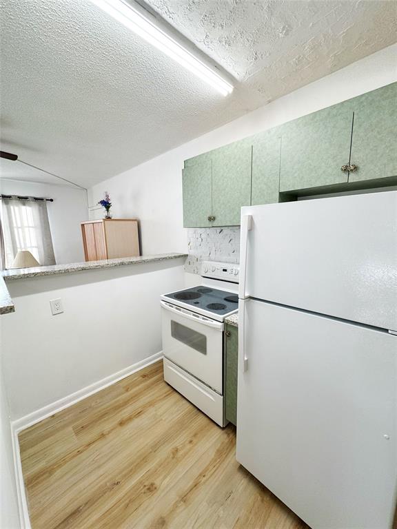 310 South Cypress Road, Unit 729 Pompano Beach, FL 33060 - Photo 5 of 30 a kitchen with a refrigerator and a stove