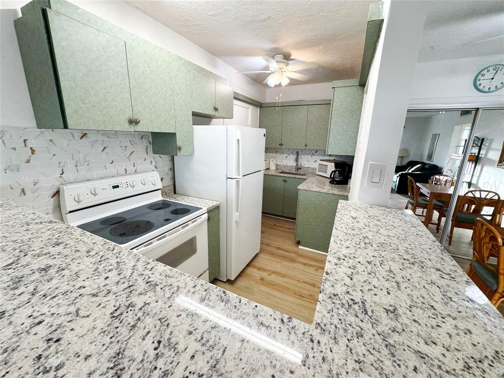 310 South Cypress Road, Unit 729 Pompano Beach, FL 33060 - Photo 6 of 30 a kitchen with refrigerator cabinets and wooden floor