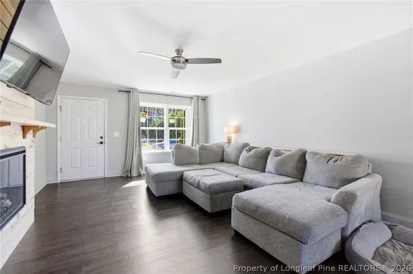 a living room with furniture a fireplace and wooden floor