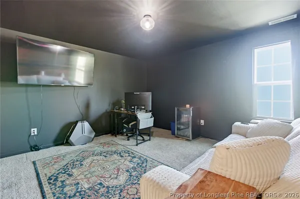 a living room with furniture a piano and a bookshelf
