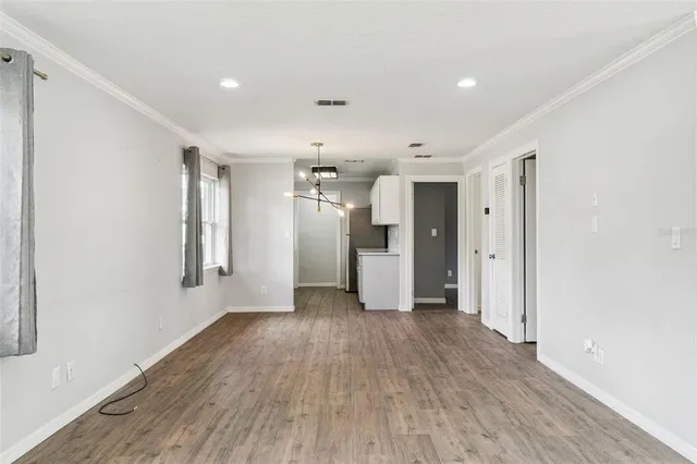 a view of a big room with wooden floor and a window
