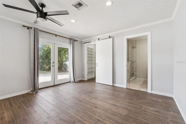 a view of empty room with wooden floor and fan